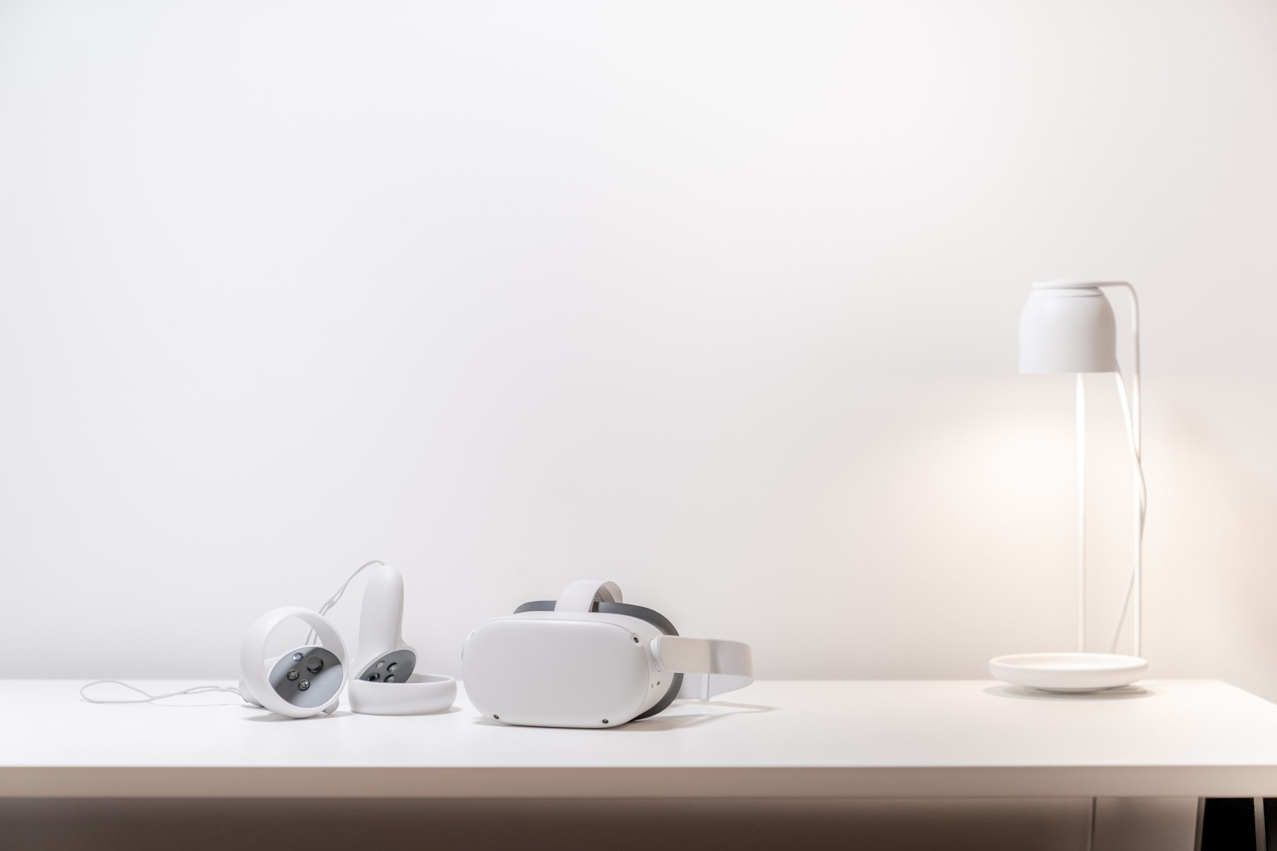 Vr headsets and a lamp on a white table.