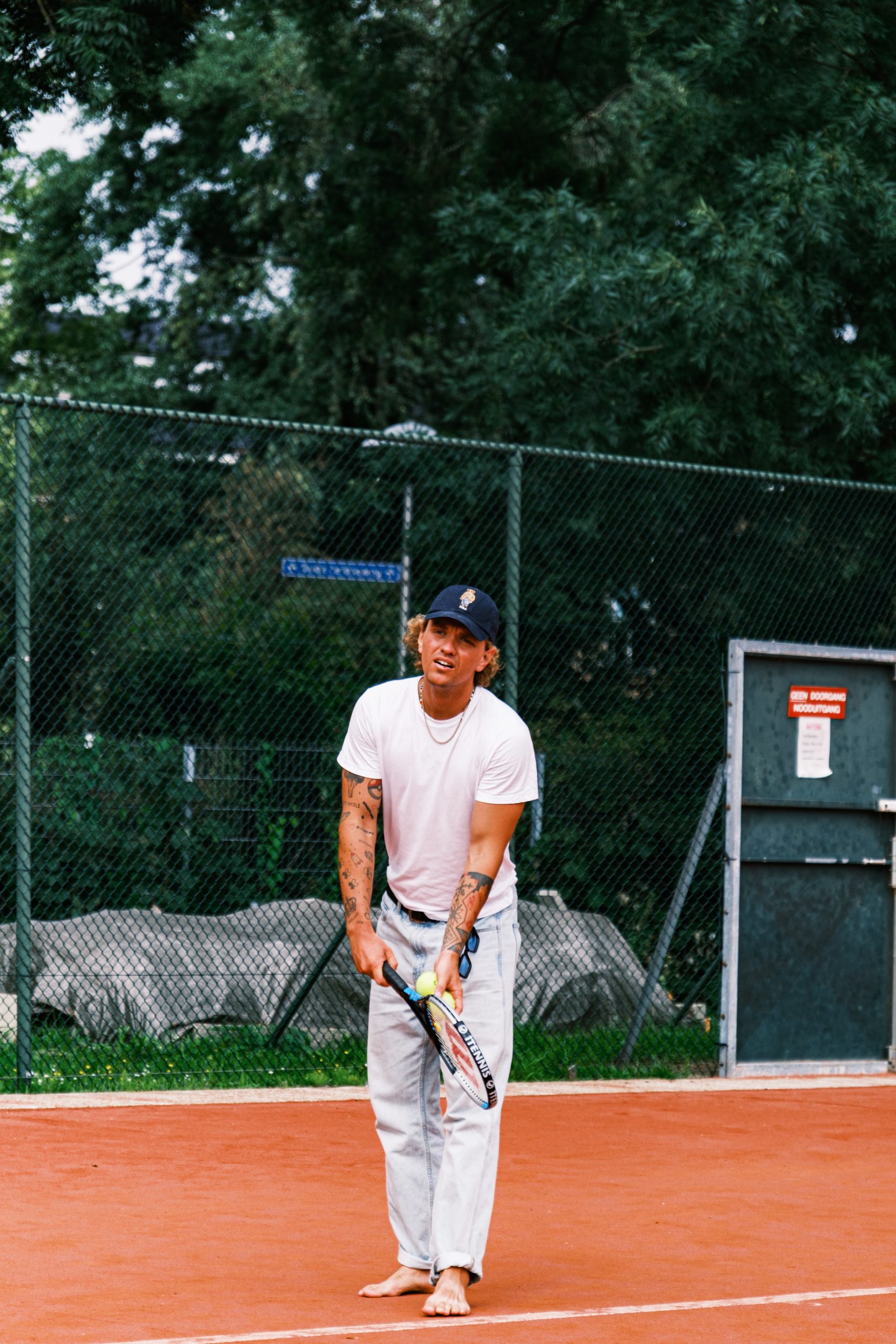 A man holding a tennis racket on a tennis court.